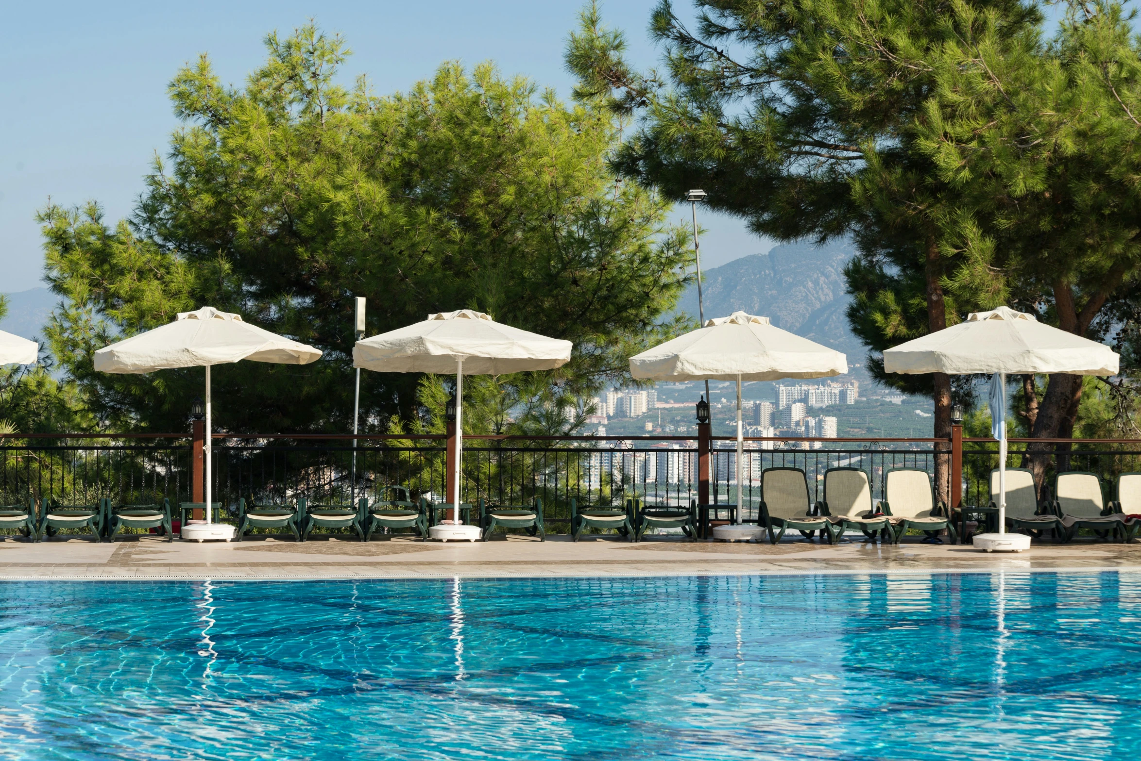 a row of tables and chairs around a swimming pool