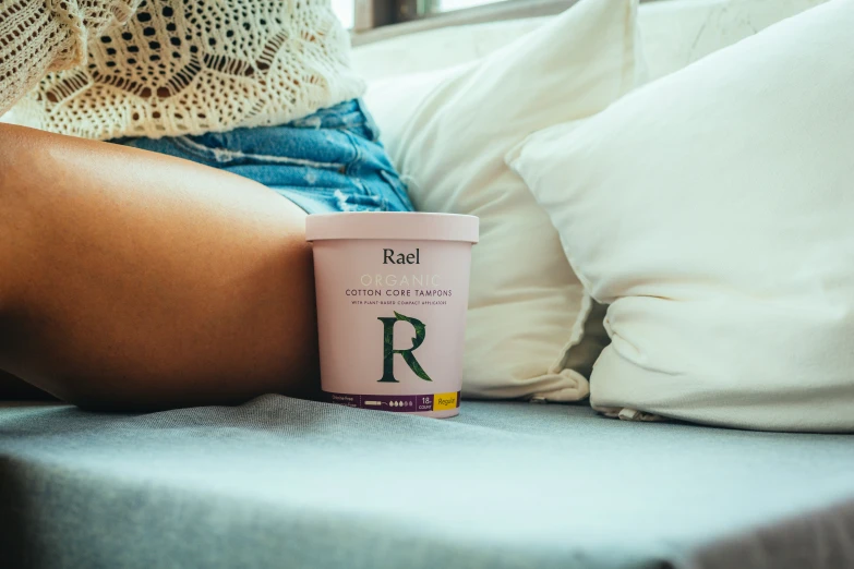 a person laying on a bed holding a coffee cup