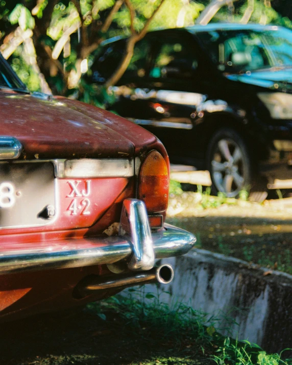 the rear end of an old car parked on grass