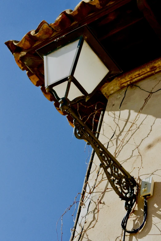 a lamppost with a light that is broken on a building