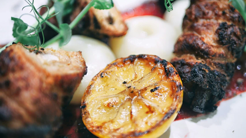 a plate with some meat and a slice of orange