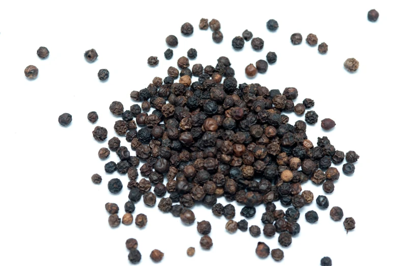 a pile of black pepper on a white background