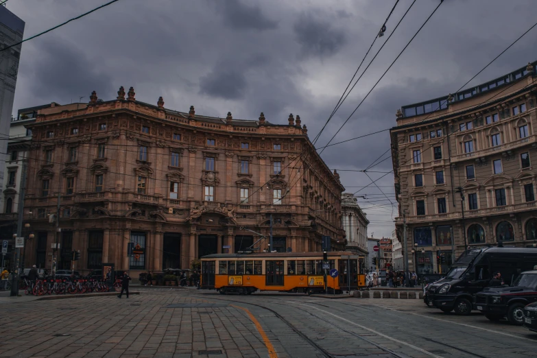 a yellow and black train some cars buildings and cars