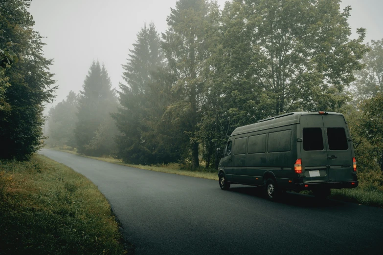 the rear end of a van driving down a country road