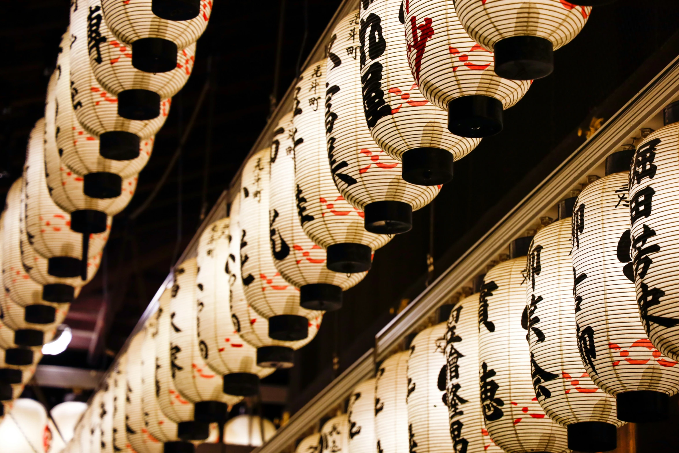 rows of asian hanging lanterns with signs on them