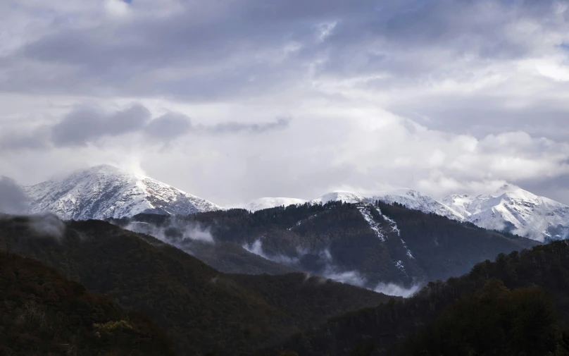 a bunch of hills and trees under some clouds