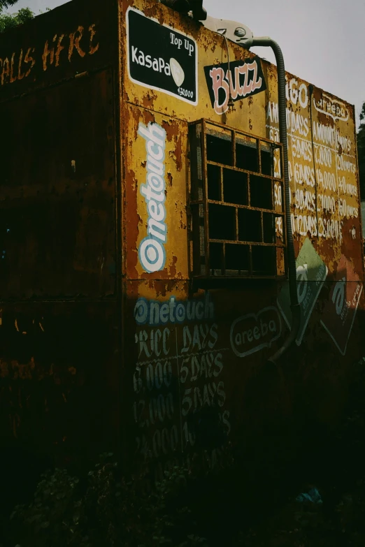 a rusty food truck with graffiti on it and many other signs on the side