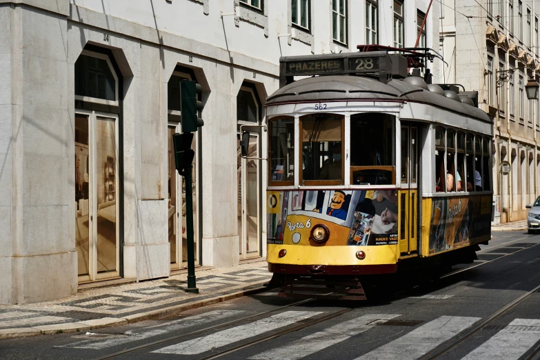 a trolley is passing a light rail stop in an urban area