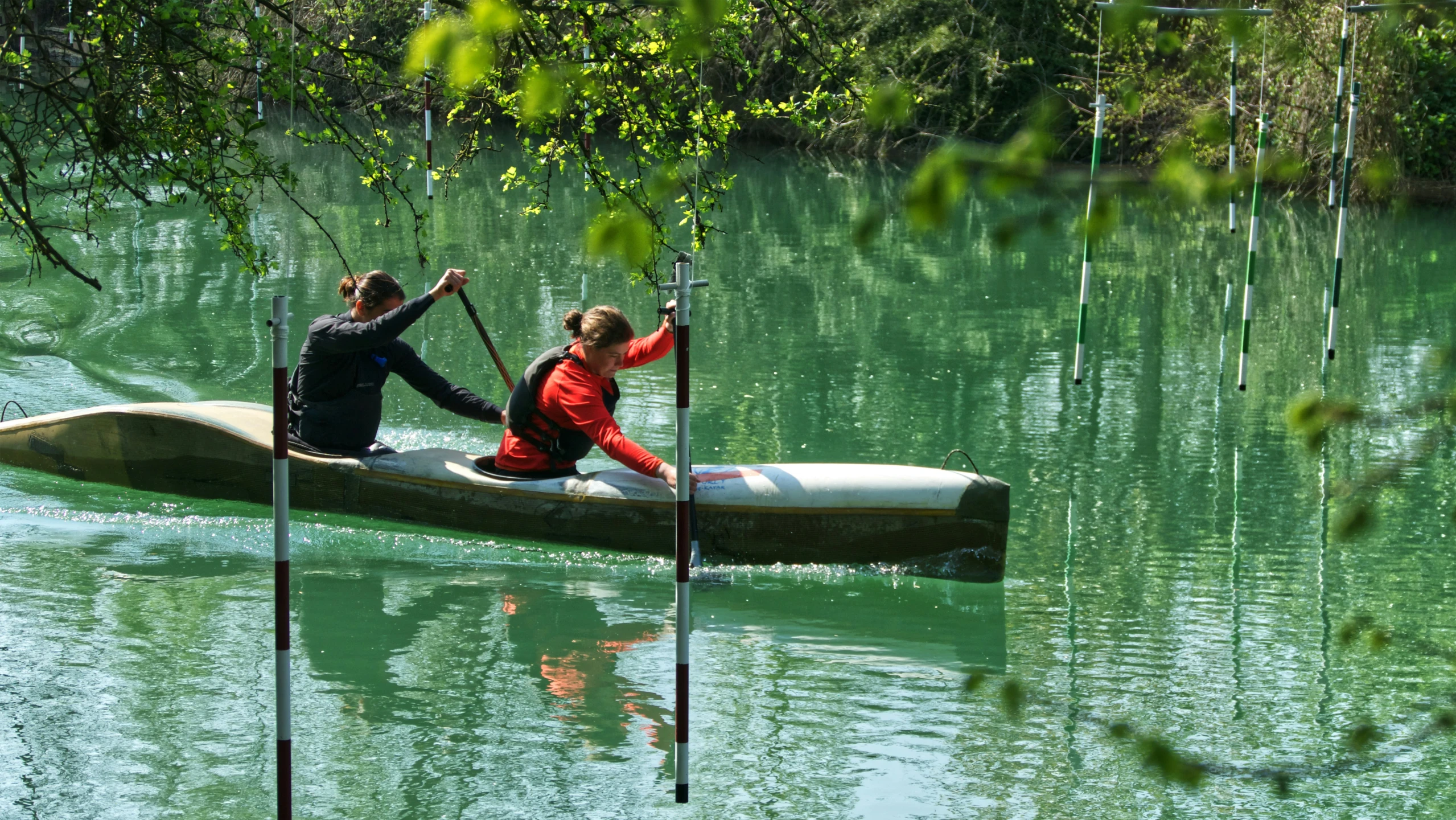 two people are rowing a canoe in the water