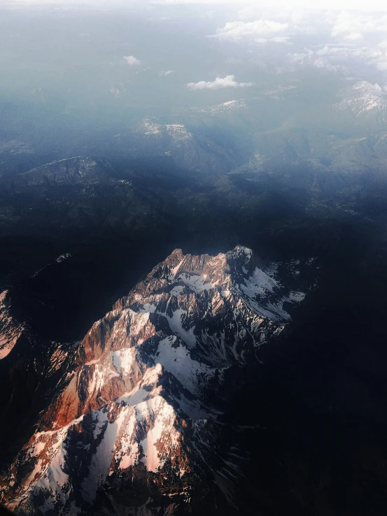 a view of a snow covered mountain from a plane