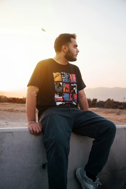 a young man sitting on the top of a ledge