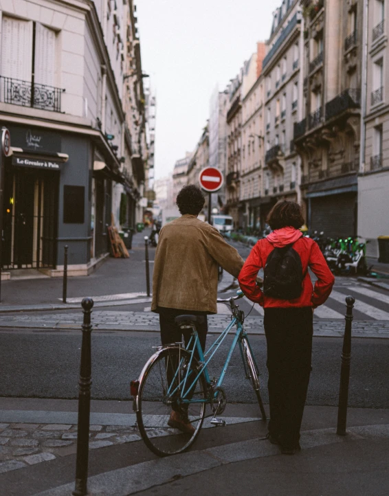 two people on bikes stop to cross the street