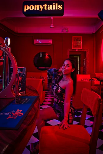 woman in a dark restaurant with a neon sign