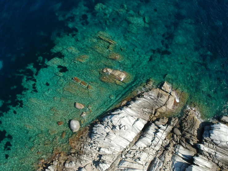 a body of water next to rocks on a beach