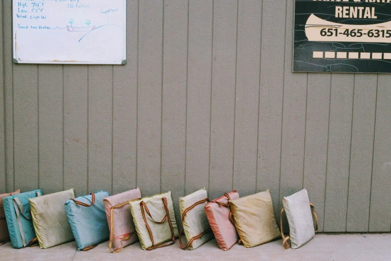 four cushions lined up next to a gray wall