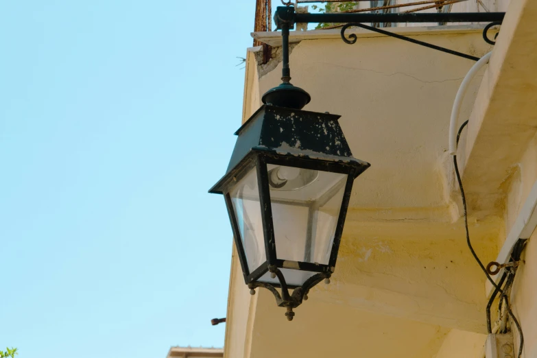an old fashioned street lamp attached to a building