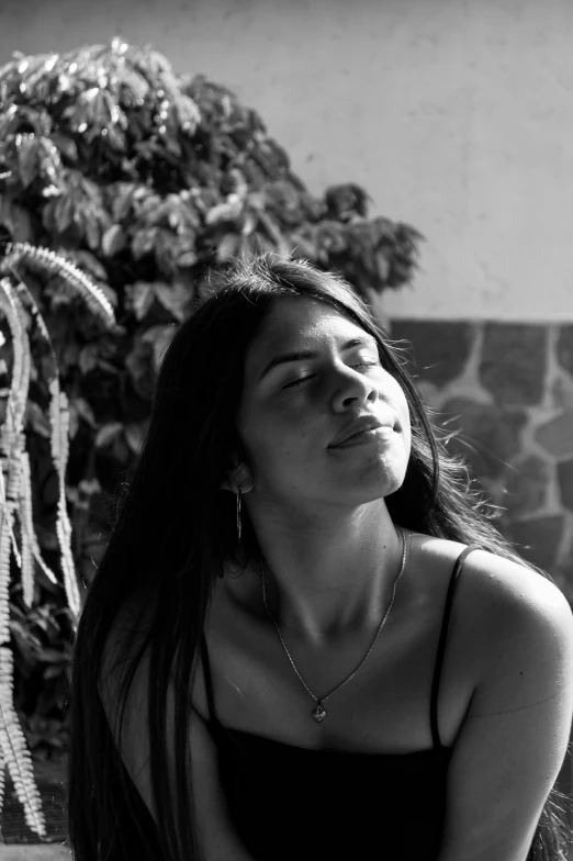 a woman in black  top sitting with head tilted in back