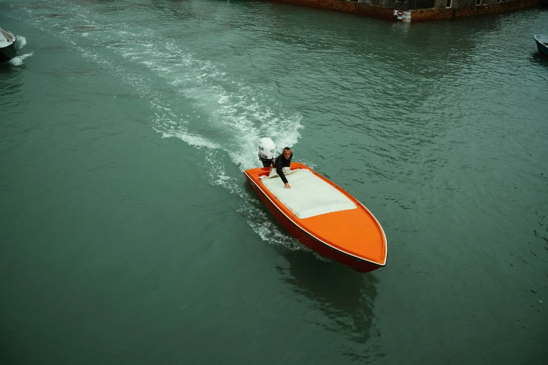 two people are in a small motor boat going across the water