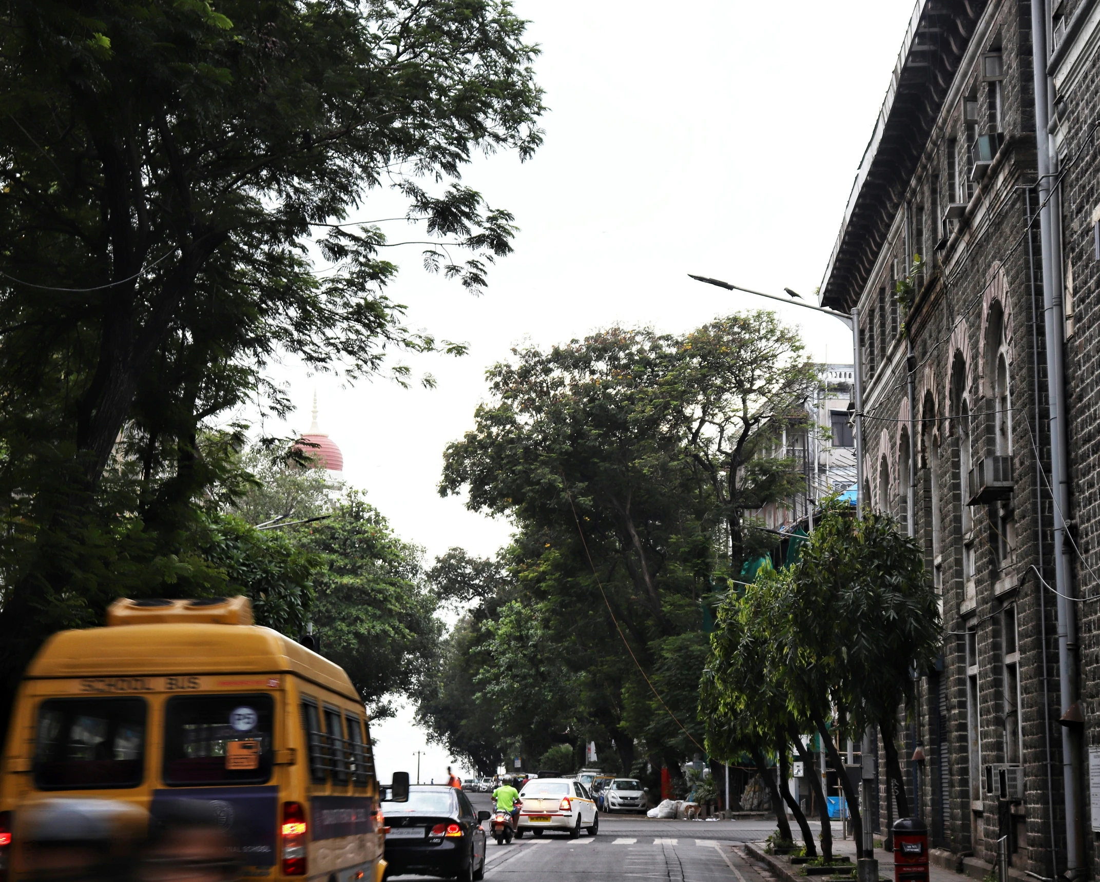 the city street is full of traffic, including a yellow bus