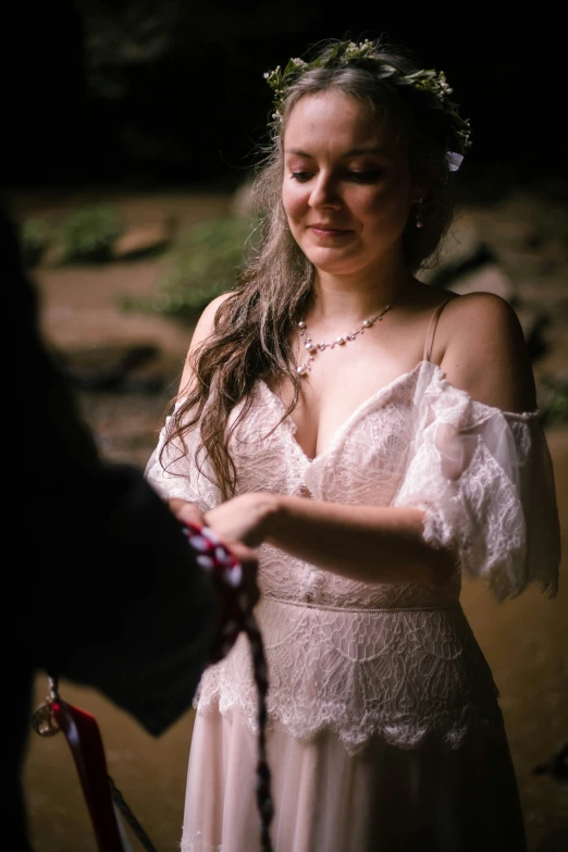 a girl in an off - shoulder dress holding a red hook in her hands