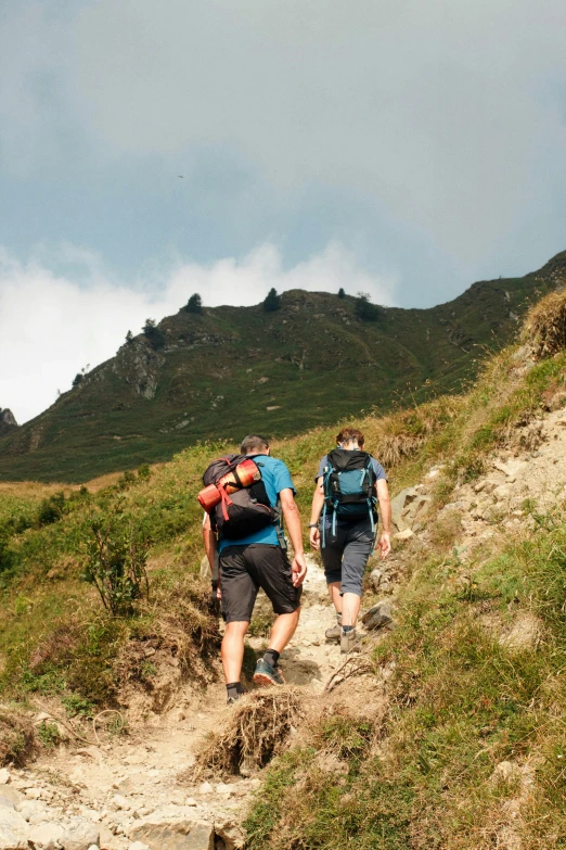 two men walking up a trail with their packs on