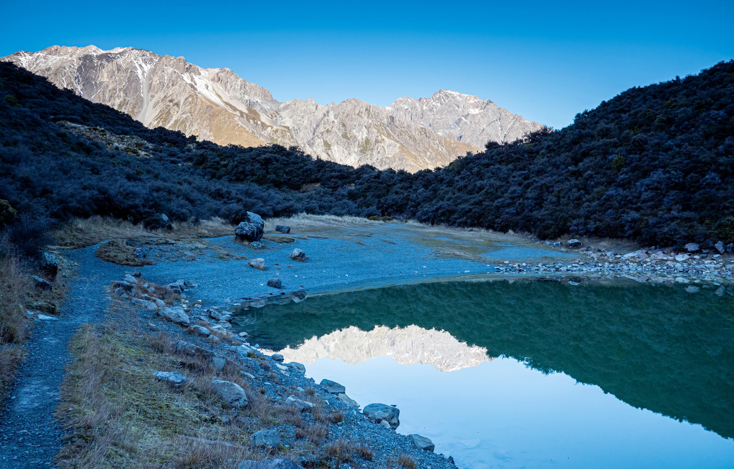 the mountains in the background are reflecting the water