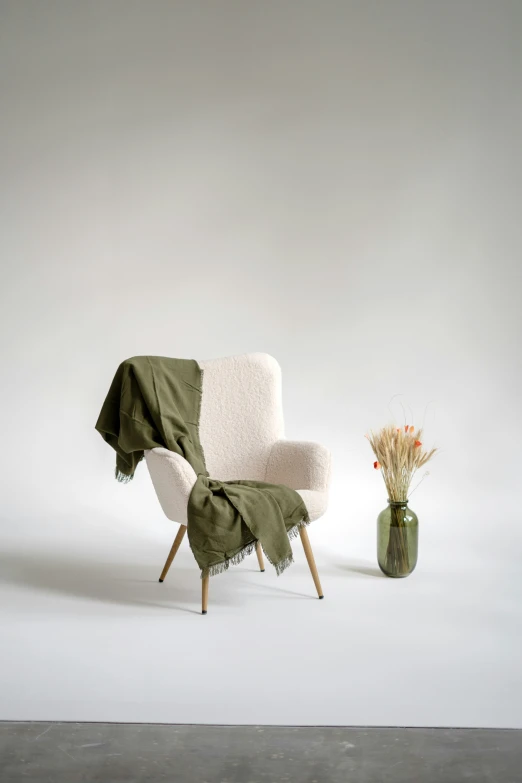 an empty chair and vase sitting in front of a white background