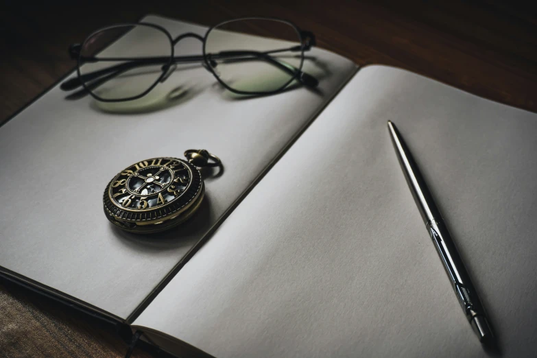 a pen and eye glasses on top of an open journal