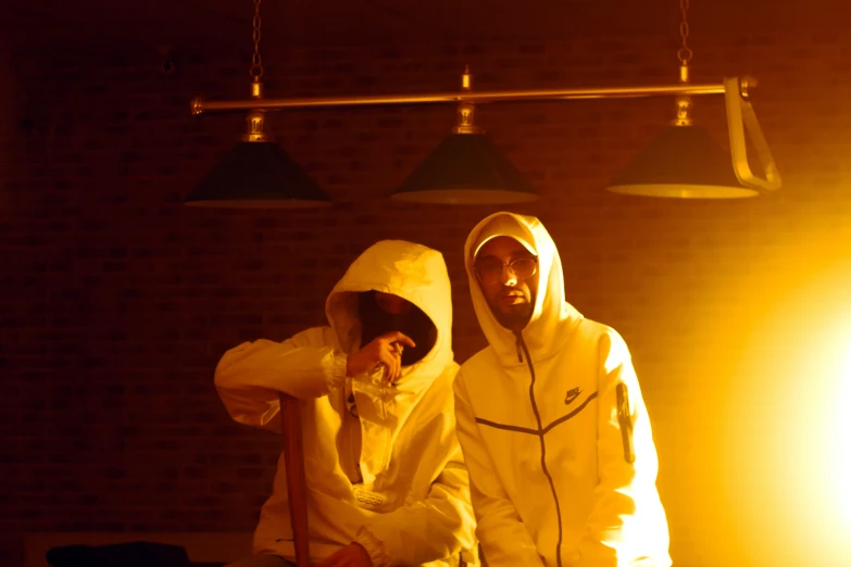 two people in raincoats standing next to a wall