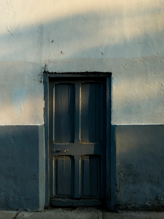 there is a old door in the cement wall