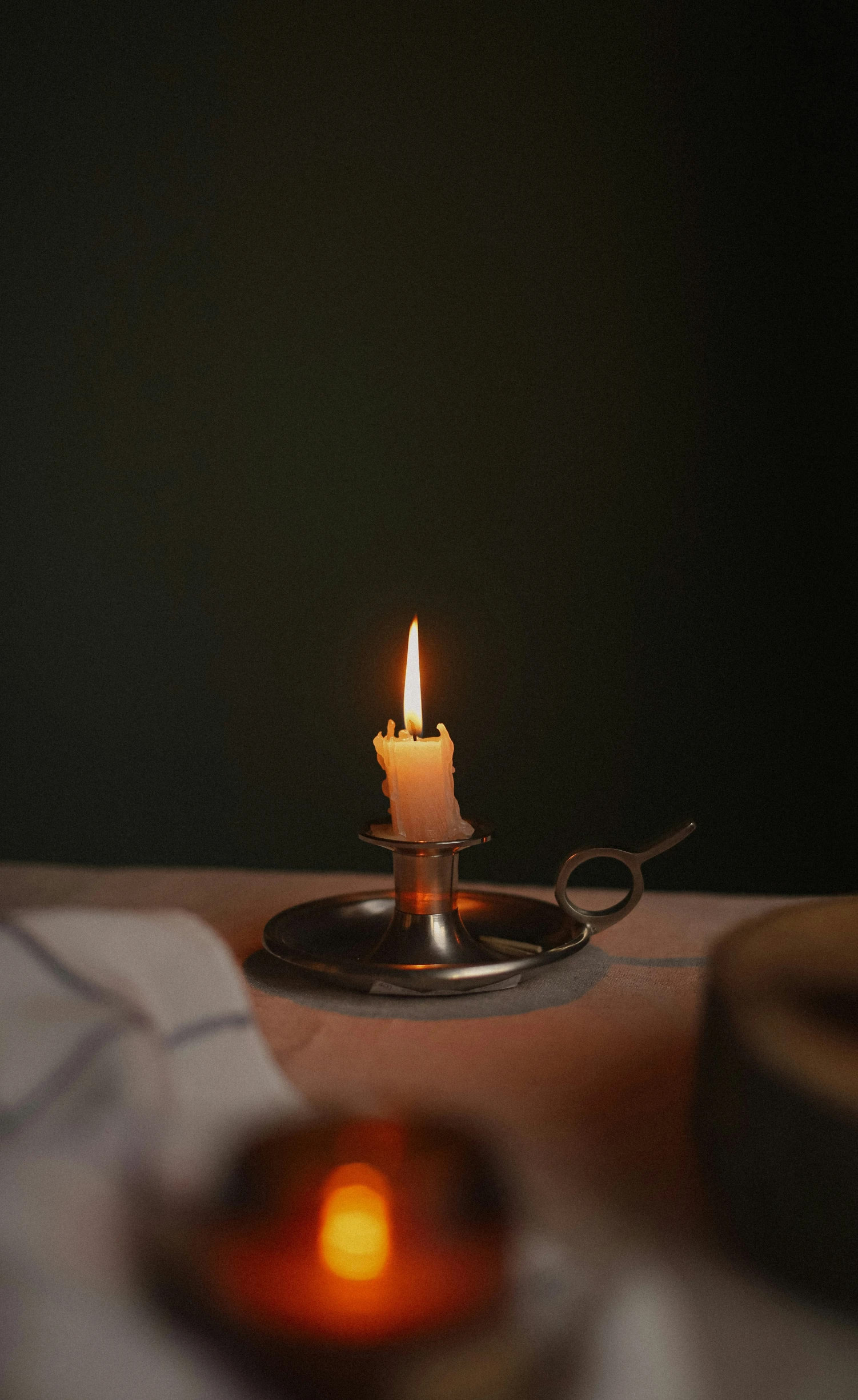 a lit candle and a bowl of candles