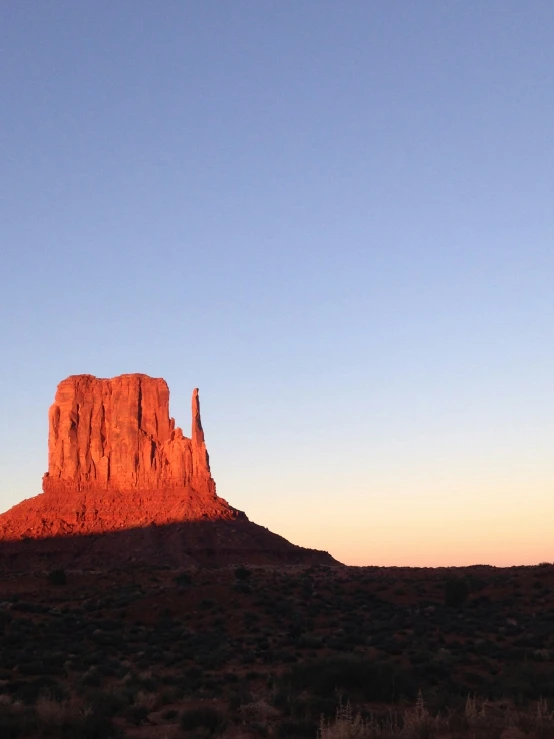 an orange mountain is in the background with some clouds