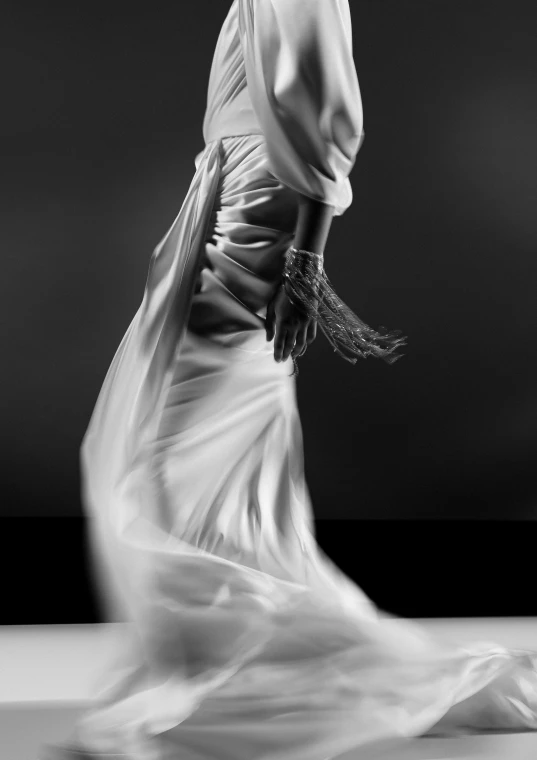 a black and white po of a woman in a long dress