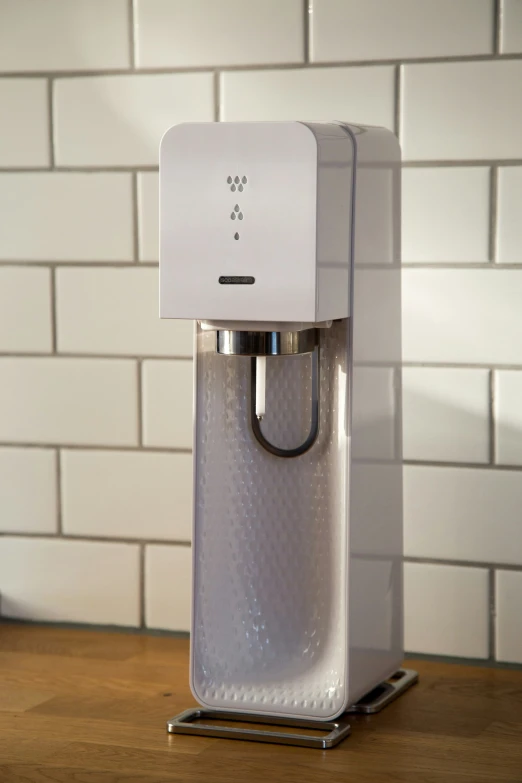 a white and chrome coffee maker sitting on top of a wooden counter