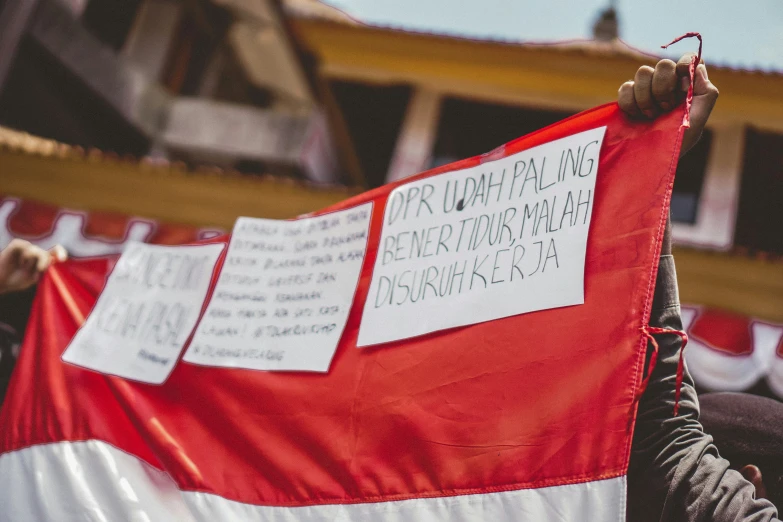 a group of people holding a large flag that says on it