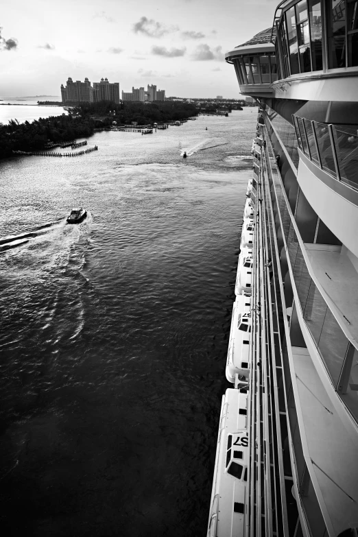 several passenger boats near a city while people ride on the bridge