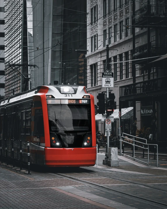 red train on tracks next to buildings in city