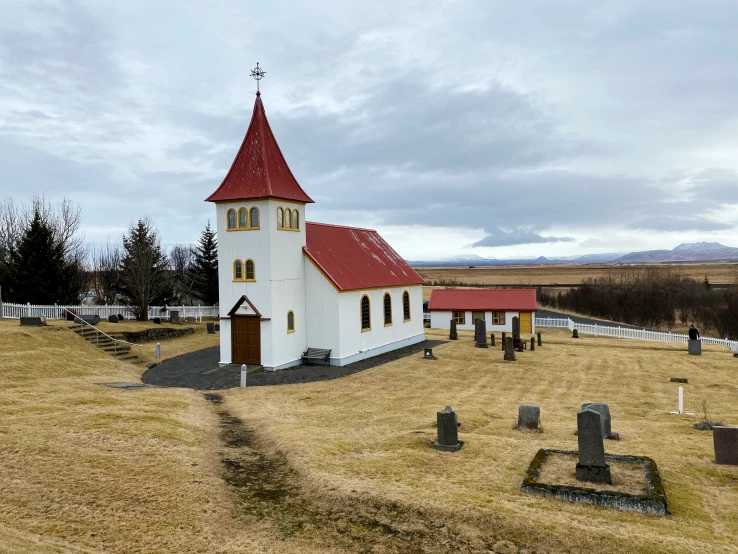 a church with a red roof in a field