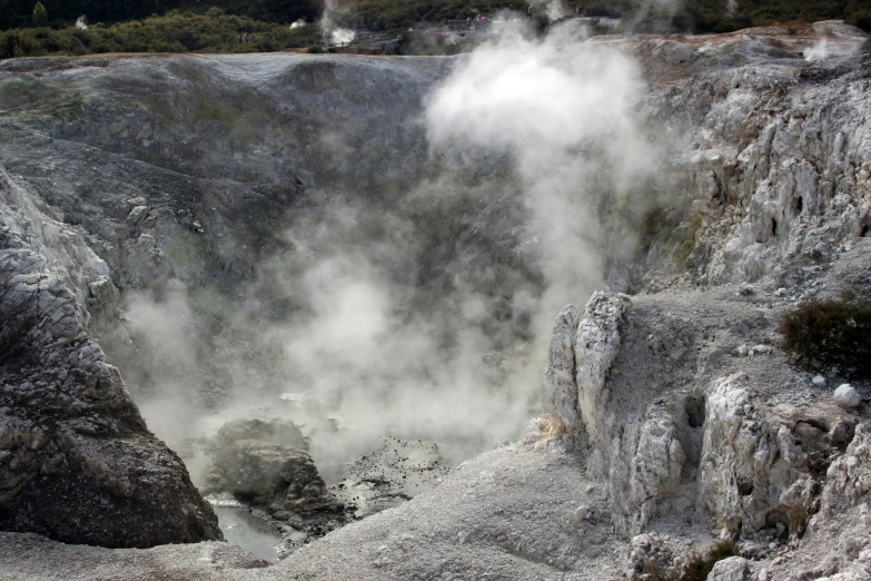 an open open pit in a mountain with steam coming from it