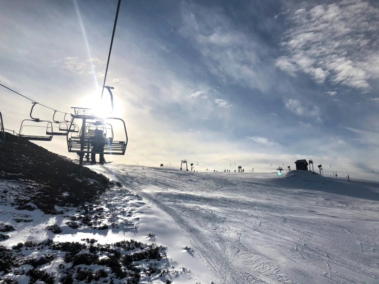 a ski lift going up the mountain with people on the skis below it