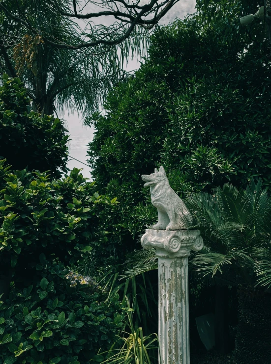 an ornate statue surrounded by trees and bushes