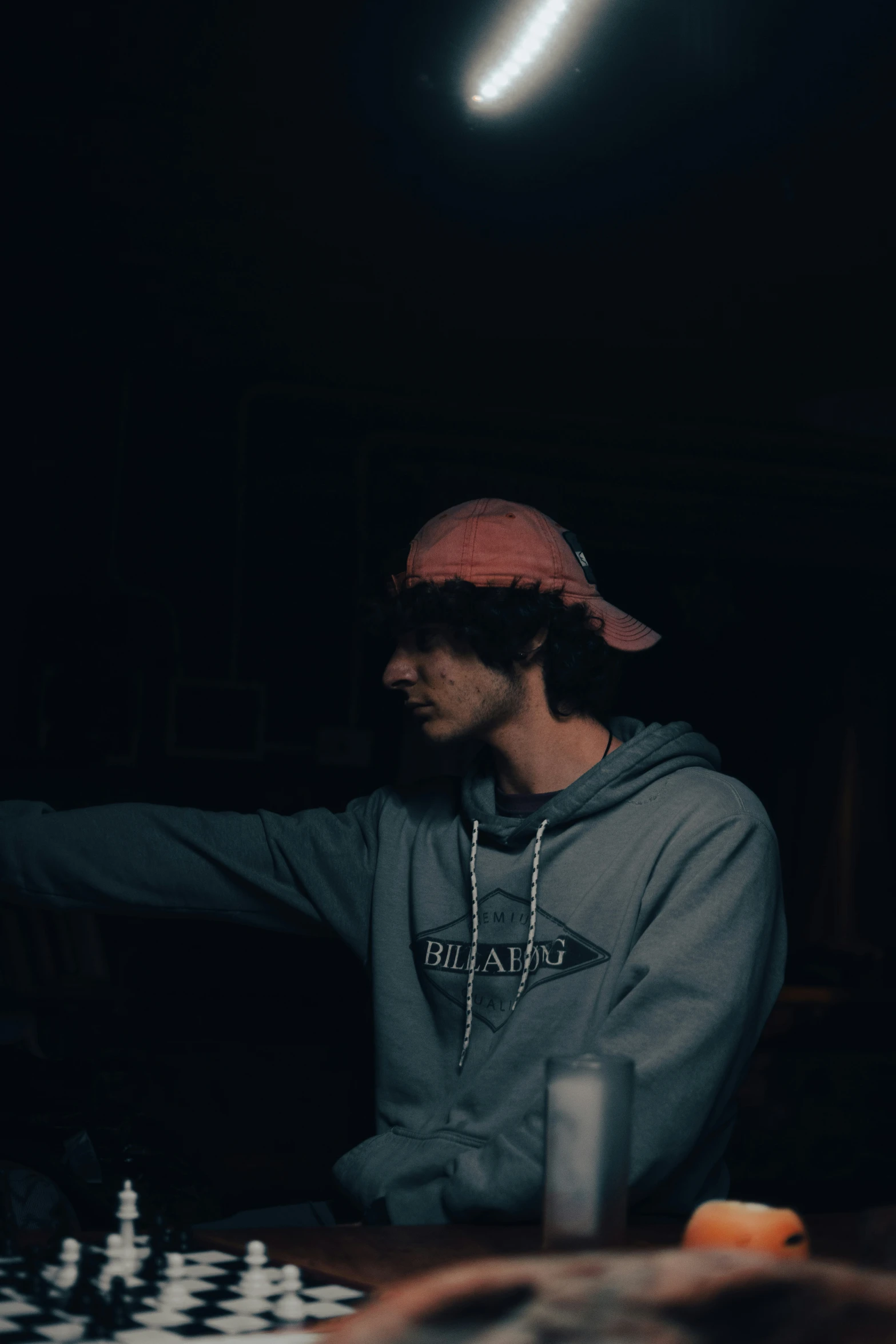 man sitting in a dark room playing chess