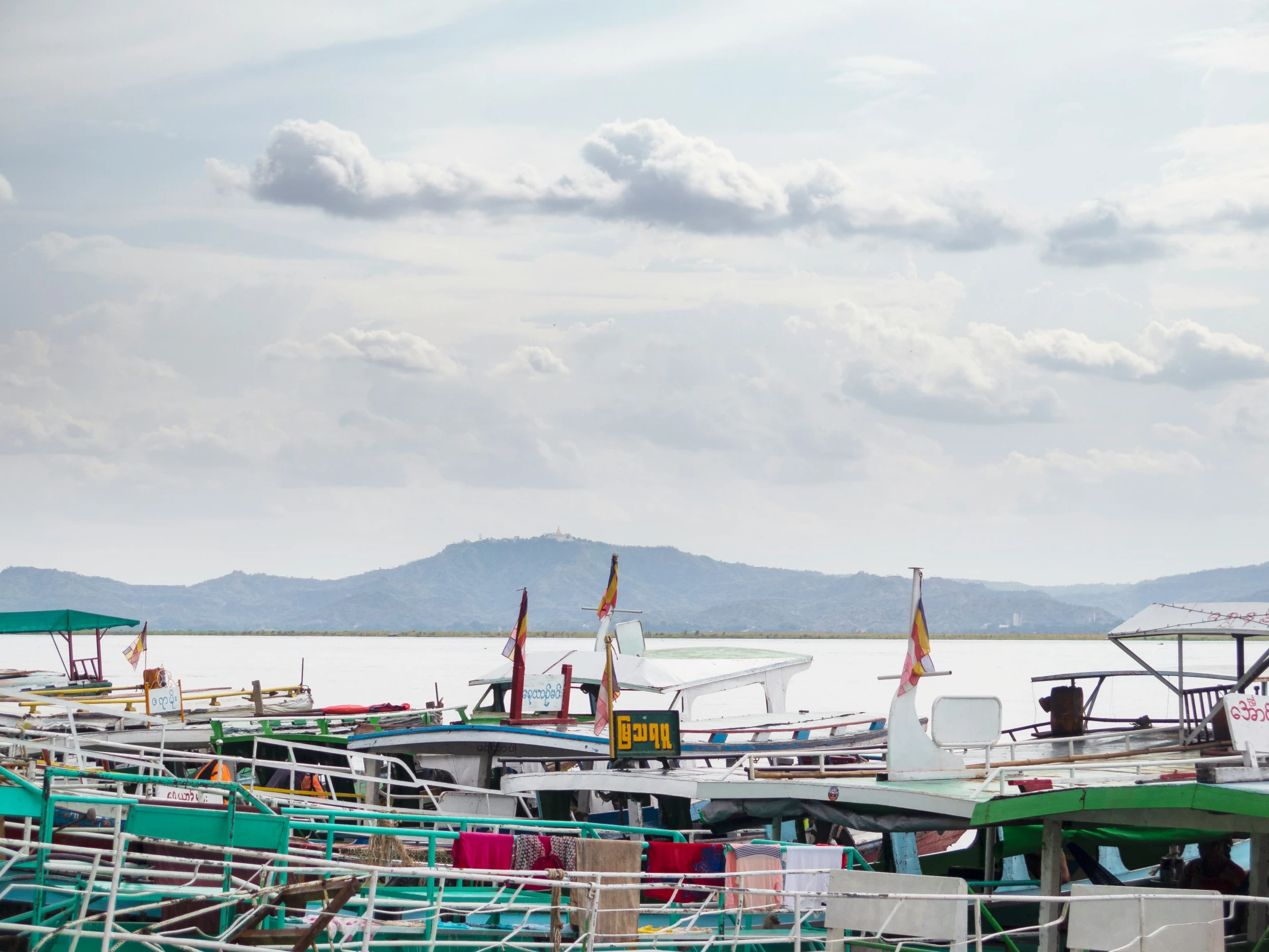 colorful boats are docked next to a mountain range