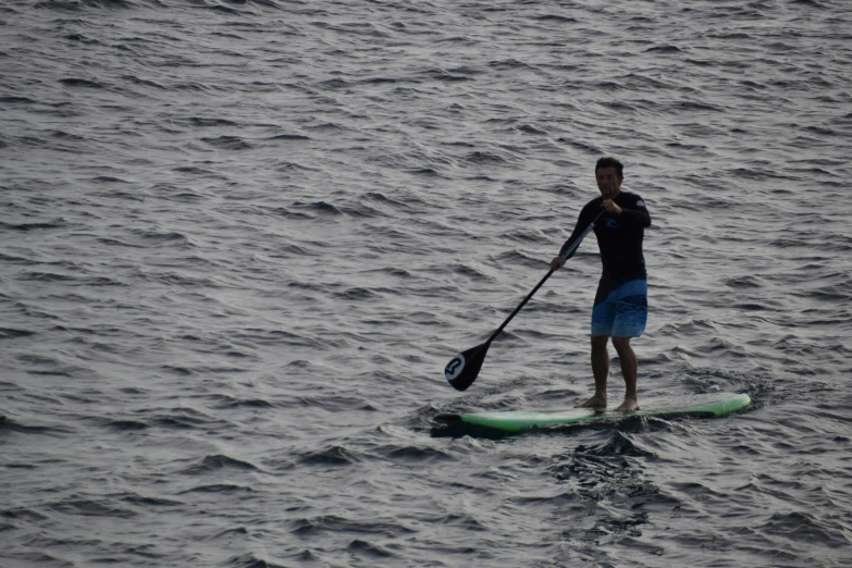 a man standing on his paddle board and paddling