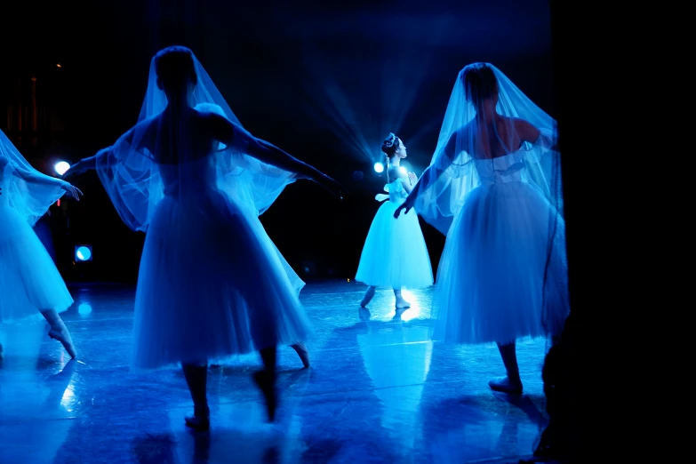 several white and blue costumes in front of blue light