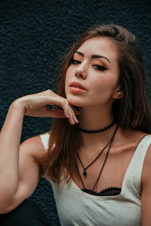 a woman wearing a long necklace looking at the camera