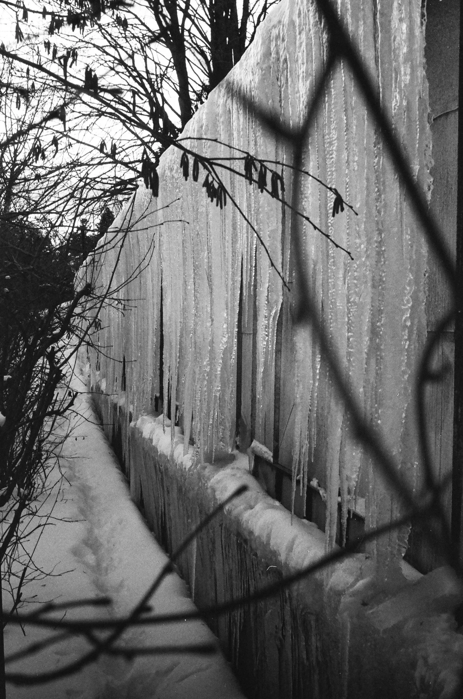 an old building in the winter that has a fence surrounding it