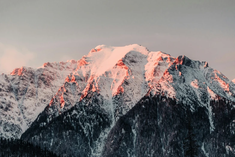mountains are covered in snow with orange lighting