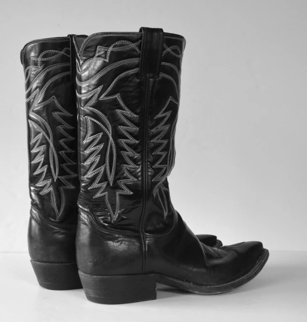 a pair of black boots with a silver decoration on the side