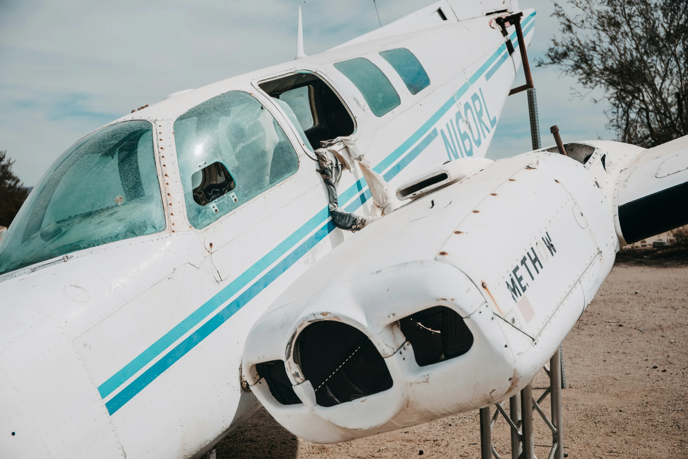 a close up of an airplane on dirt ground